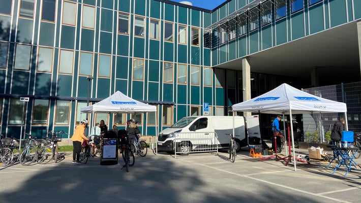 Tält med Locumlogga, cykelmekaniker och personer under cykeldag vid Danderyds sjukhus 2024.