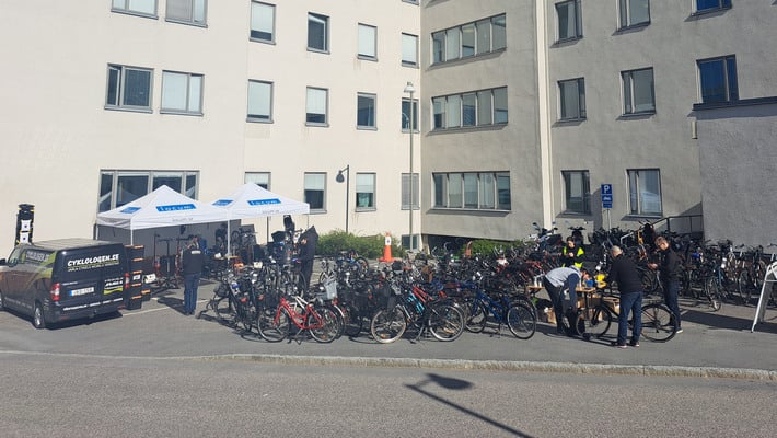 En samling cyklar uppställda utanför Södersjukhuset vita fasad.