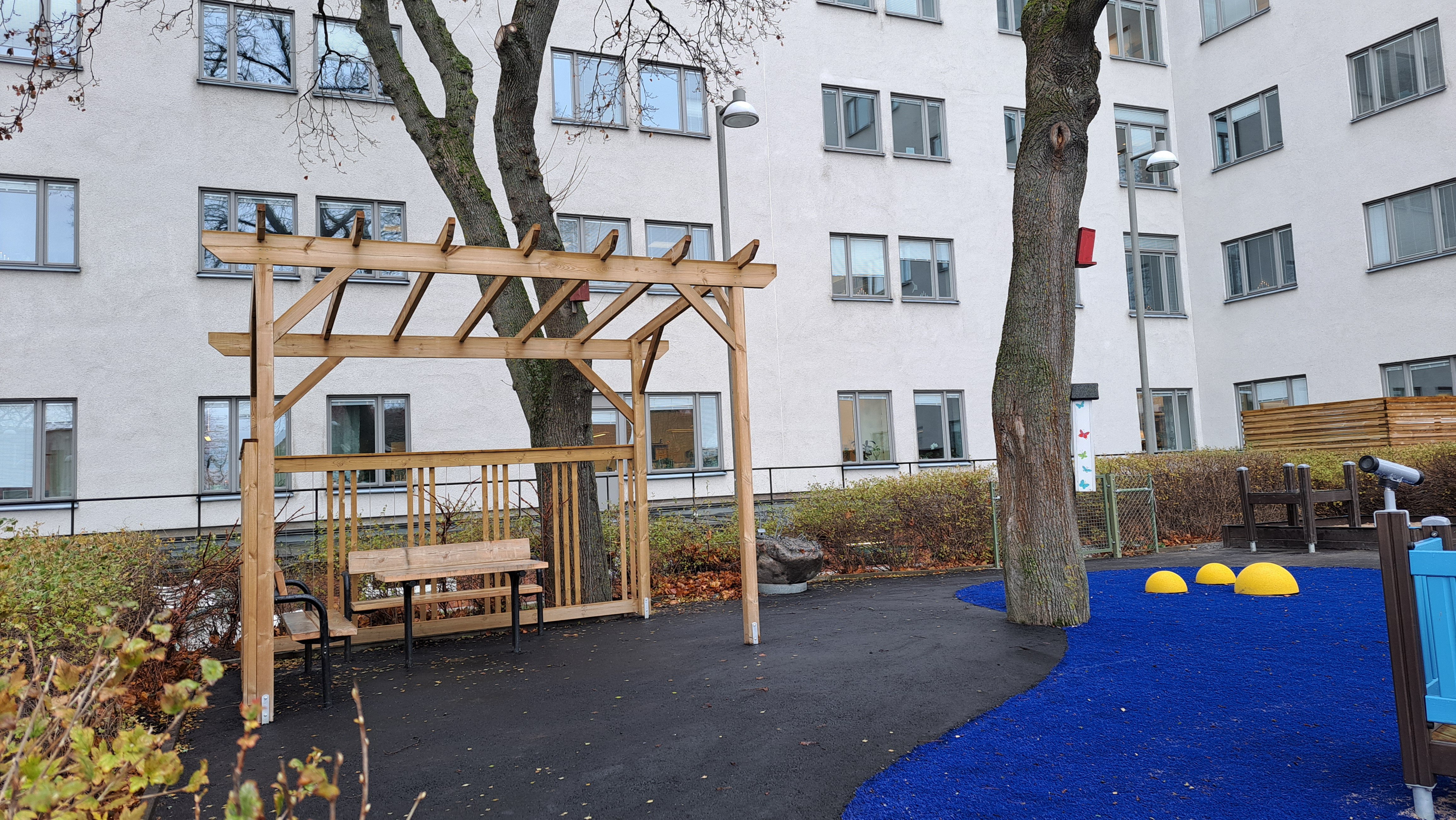 Sittplatser under en pergola.