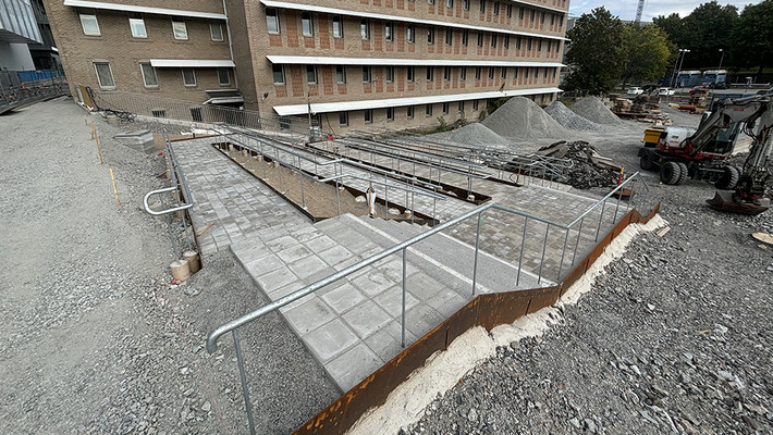 Pågående markarbeten med trappa, ledstrål och ramp vid Danderyds sjukhusområde.