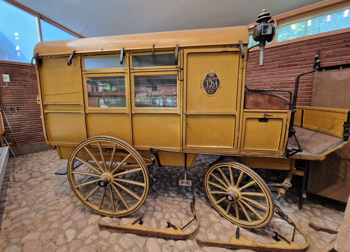 Hästdragen sjuktransportvagn från sekelskiftetVagnen tillverkades 1903-04 hos C.A. Carlssons söner mekaniska vagnfabrik, Stockholm. Till sjuktransportvagnen hör en s.k. stillebår, fyra fältbårar och slädmedar som vintertid monterades på hjulen.Vagnfabriken fick i uppdrag av drottning Sophias förening till understödjande af härens och flottans sjukvård (D.S.F), att bygga en ambulansvagn passande i såväl krigs- som fredstid. En provvagn uppvisades i maj 1903 och efter prov i fälttjänst- övningar beställdes ytterligare sex liknande vagnar.Vagnarna uppvisades vid hästutställningen i Stockholm våren 1904 och placerades därefter ut i arméfördelningsområdena i Helsingborg, Jönköping, Stockholm, Eskilstuna, Örebro och Karlstad. Modellvagnen bevarades i huvudstaden. I allmänhet hafva vagnarna omhänderhafts af brandkårerna i vederbörande städer och användts för forslande såväl af genom olycksfall skadade som af icke smittosamt sjuke till sjukhusen. 1913 deponerades en av dessa vagnar till Löwenströmska sjukhuset och användes för sjuktransport ännu in på 1920-talet.